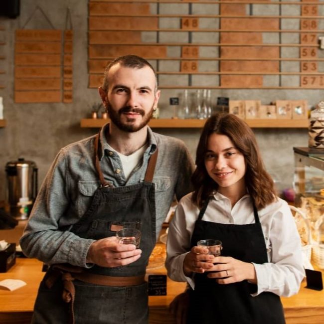 couple-aprons-posing-with-cups-coffee (1)